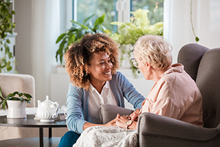 employee with elderly woman sitting in a chair