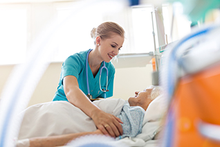 nurse tending to elderly woman in bed