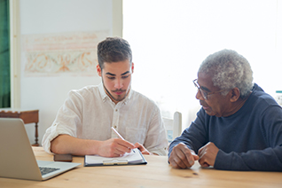 office worker with elderly man looking at documents