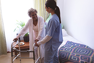 nurse with elderly woman using a walker